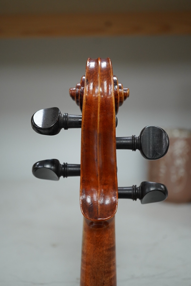 A late 19th century German violin after Pablo Maggini in bird’s eye maple with a fully mounted German bow in a crocodile skin case with retailers ivorine label reading; ‘Edward Withers, 22 Wardour Street, phone City 1899